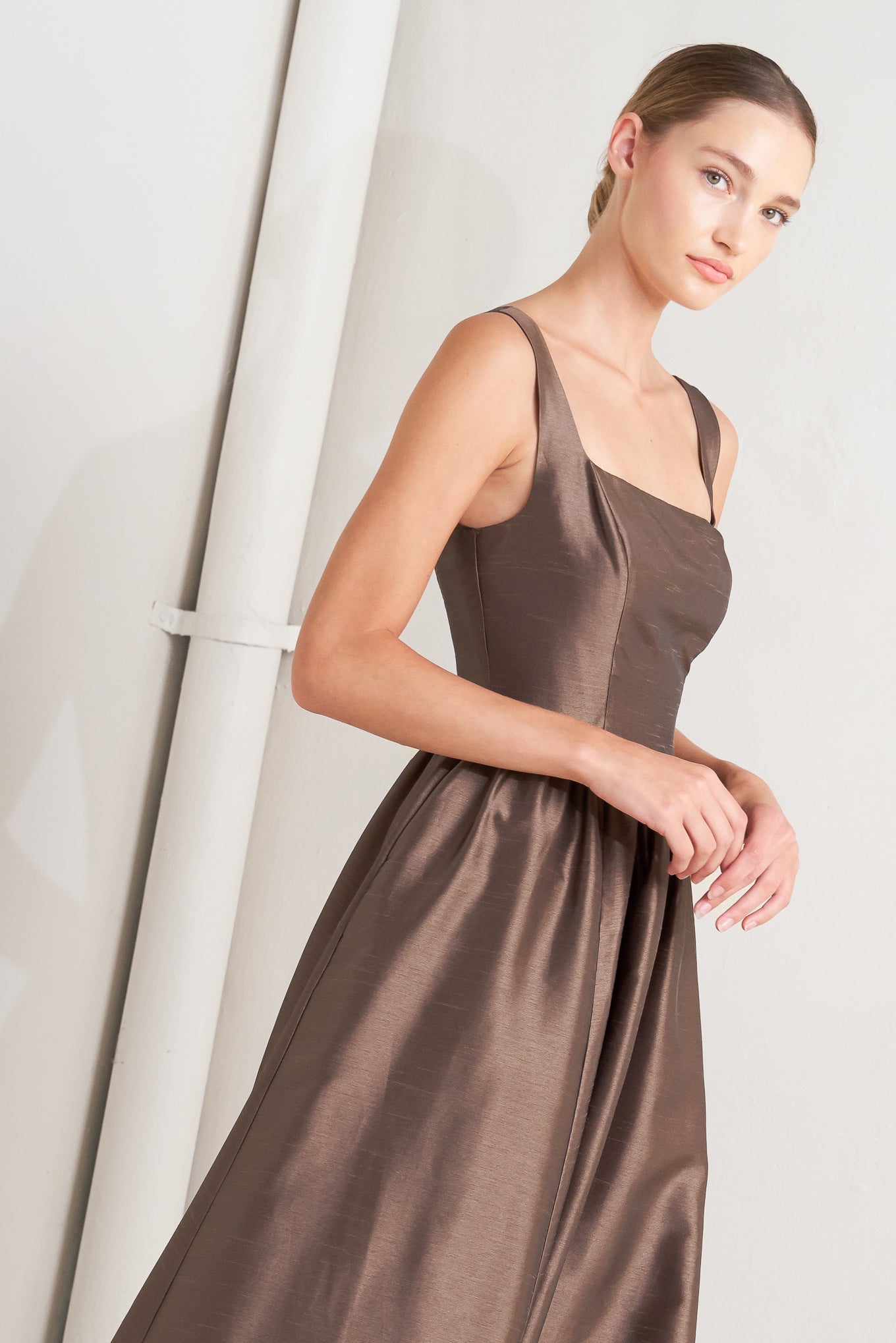 Woman wearing a brown dress against a white background