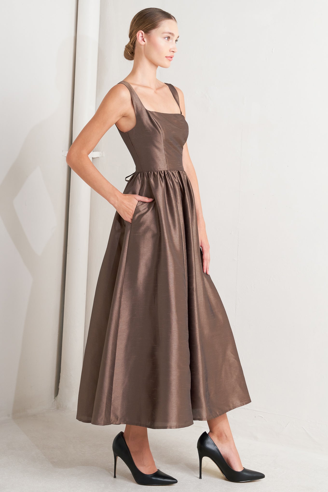 Woman wearing a brown dress against a white background