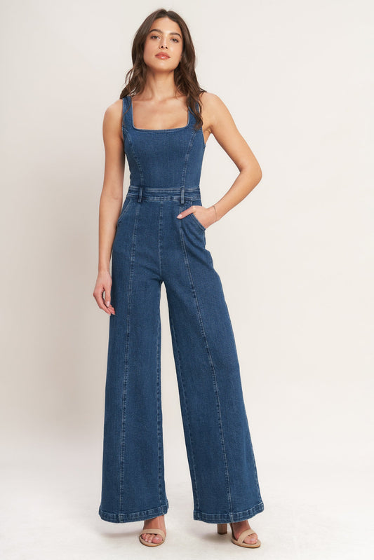 Woman wearing a blue denim jumpsuit on a white background